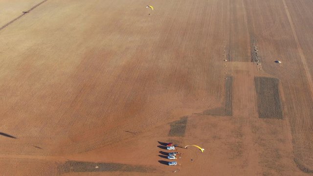 Wide aerial view showing powered paragliding enjoying flying in summer day
