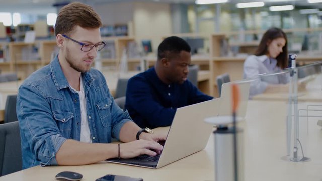 Multicultural group of students studying in a public library