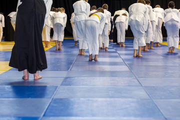 People in kimono warming up on tatami on martial arts training seminar