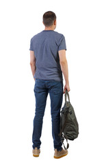 Fototapeta premium Back view of a man with a green bag.