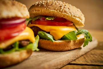 Close up of tasty hamburger on wooden table and black background