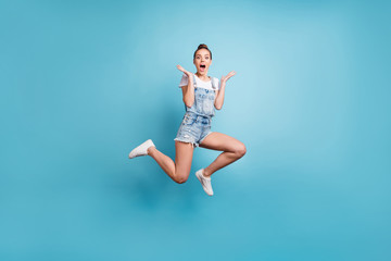 Full length body size photo of delighted astonished amazed girl seeing something unbelievable while isolated with blue background