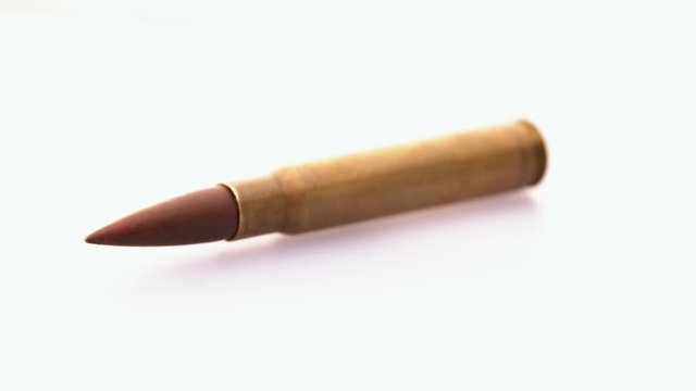 Sniper rifle bullet with shell casing on a white background, rotating product shot