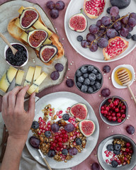 Breakfast with fruit, cheese, yogurt, granola and jam.