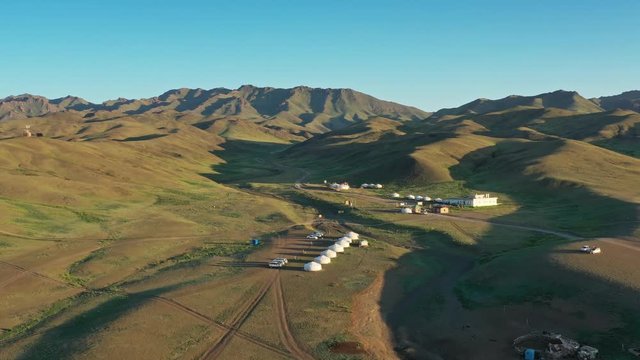Aerial view of traditional yurts between montains at sunset, Mongolia, 4k