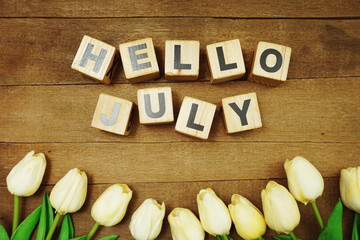 Hello July alphabet letters on wooden background