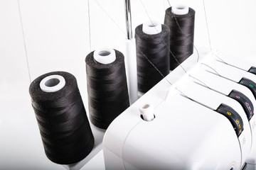 Black thread bobbins on overlock. Sewing machine.