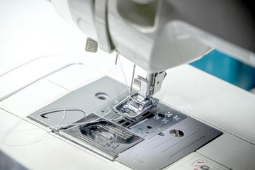 The seamstress is using the sewing machine.