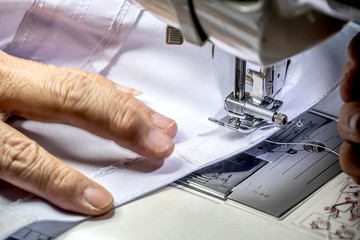 The seamstress is using the sewing machine.