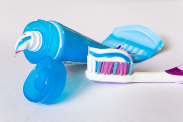 Multi-colored toothpaste on a toothbrush and tube.