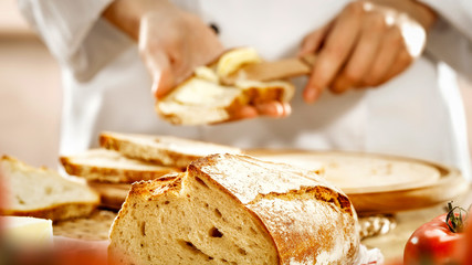 Chef’s female hands preparing food in the kitchen. Baking a cake and bread. A woman in white chef uniform.