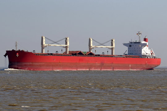 roter Massengutfrachter mit Kr&auml;nen