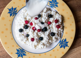 Cottage cheese with fresh blueberries and lingonberries in a bowl for healthy breakfast