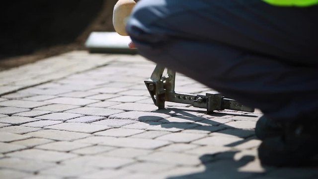 Stone Pavement Road Construction Workers Removing Blocks Using An Extractor Tool