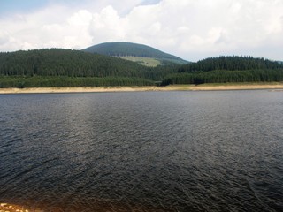 Mountain landscape with lake, trees and clouds