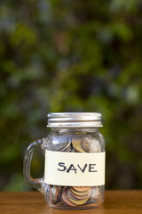 Jar with coins and save label with blurred background