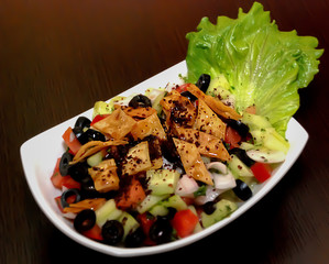 Fatush salad in the white bowl on the dark brown table