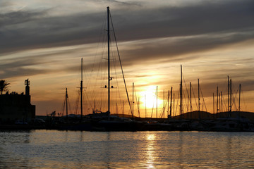 Fototapeta premium Panoramic view of marina at sunset. Colorful landscape on a summer night in Alghero, Sardinia, Italy.