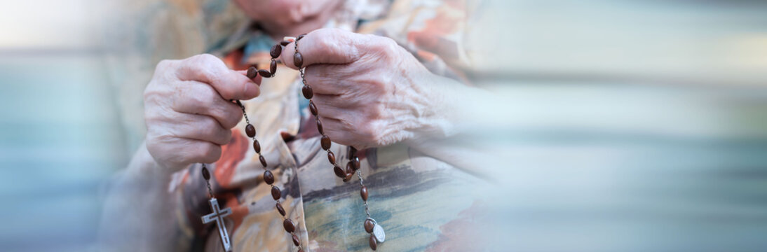 Old woman praying; panoramic banner