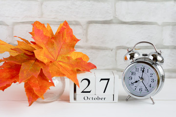 October 27 on a wooden calendar next to the alarm clock, the date of the autumn month.The concept...