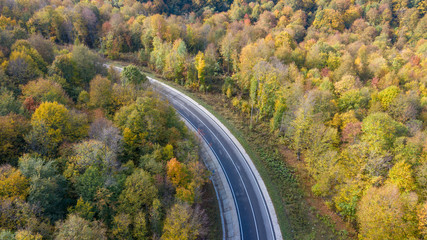 autumn in the mountains, asphalt road among the mountains in the autumn forest