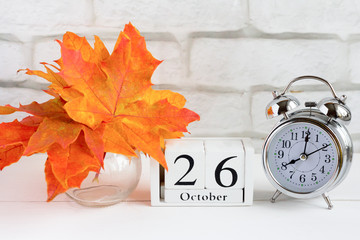 October 26 on a wooden calendar next to the alarm clock, the date of the autumn month.The concept of Golden autumn