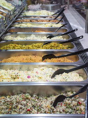 Sideways view of trays of various types of salads at a salad bar in a supermarket