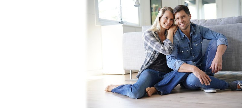 Happy Middle-aged Couple At Home Sitting On Floor