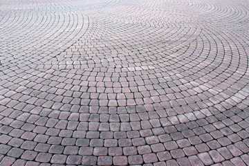 Stone pavement in perspective. Stone pavement texture. Granite cobblestoned pavement background.