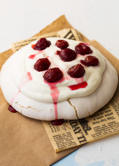 Meringue dessert Pavlova cake with fresh berries, mint on a stone background