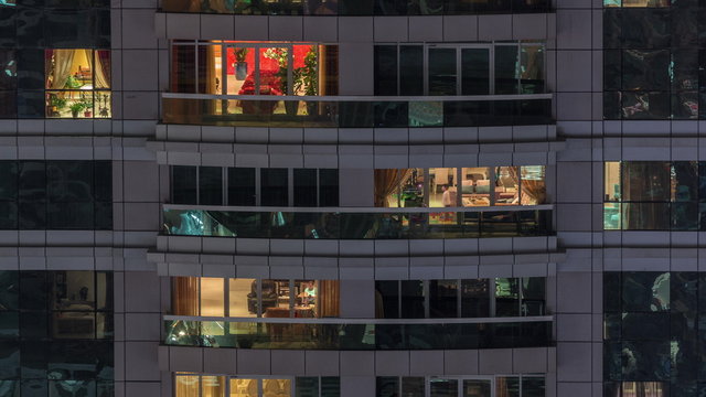 Night View Of Exterior Apartment Building Timelapse. High Rise Skyscraper With Blinking Lights In Windows