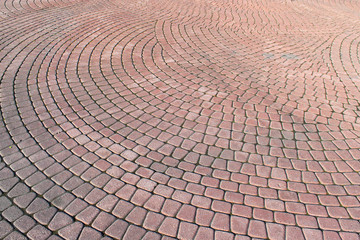 Stone pavement in perspective. Stone pavement texture. Granite cobblestoned pavement background.