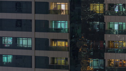 Night view of exterior apartment building timelapse. High rise skyscraper with blinking lights in windows
