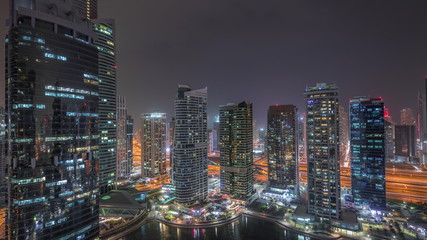 Obraz na płótnie Canvas Residential and office buildings in Jumeirah lake towers district night timelapse in Dubai