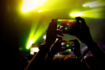 Smartphone in hands during music show.