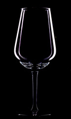 Glass of Bordeaux for red wine on a black background, contour light, studio.