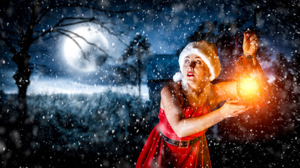 Slim young woman with lamp and christmas night 