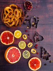 Fall and winter ingredients still life with grapefruits, lemon,cydonia, cranberries, herbs, dried apples, cinnamon sticks, spices, raisin on wooden background, antioxidants, vitamin C rich food