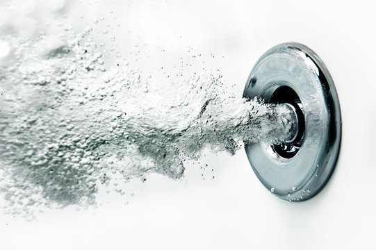A nozzle blows air under water in a bath tub.