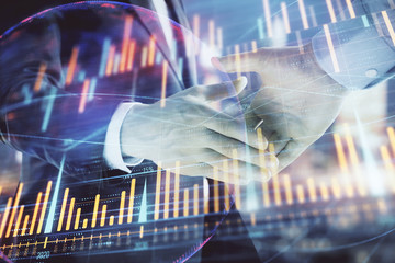 Double exposure of financial chart and world map on cityscape background with two businessmen handshake. Concept of international investment