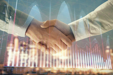 Double exposure of financial chart on cityscape background with two businessmen handshake. Concept of financial analysis and investment opportunities