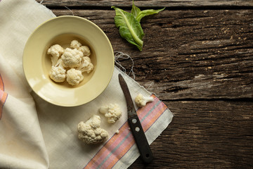 Cooking Cauliflower. Top view, wooden table.In a plate are slices of cabbage
