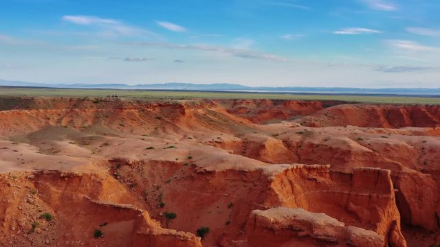 Aerial view of the Bayanzag flaming cliffs at sunset in Mongolia, found in the Gobi Desert, 4k