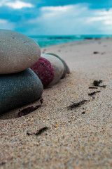 Fototapeta na wymiar Zen stones on the beach with sand and sea view