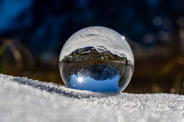 lens ball at the beautiful offensee in the heat of Austria's alps. crystal ball in the snow in austria Europe. Great glas ball photography during winter season in austria