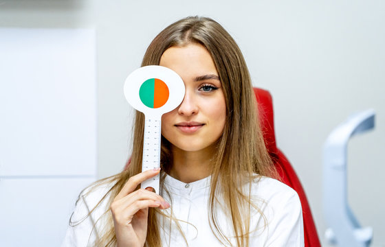 Young Woman doing eye test. Eyesight correction. Blonde girl in ophthalmolory. Optics clinic.