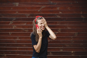 Young girl talks on the phone in shock.
