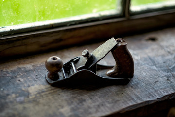Old wooden jointer near window. Tool for carpentry work.
