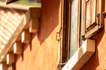 The wooden windows have glass on the inside with the plaster walls of a vintage house.