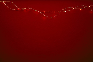 Red background with illuminated lights of garland